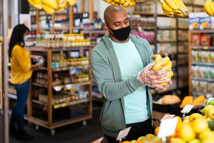 homem escolhendo frutas no mercado