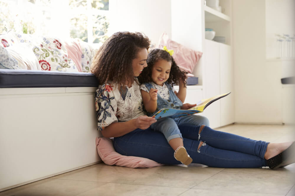 Livros Para Ler Com Os Filhos: Mãe E Filha Sentada Juntas Lendo Um Livro