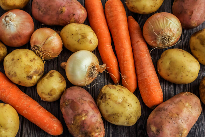 Tubérculos diversos, entre cenouras, batatas e batata-doce, além de cebolas.