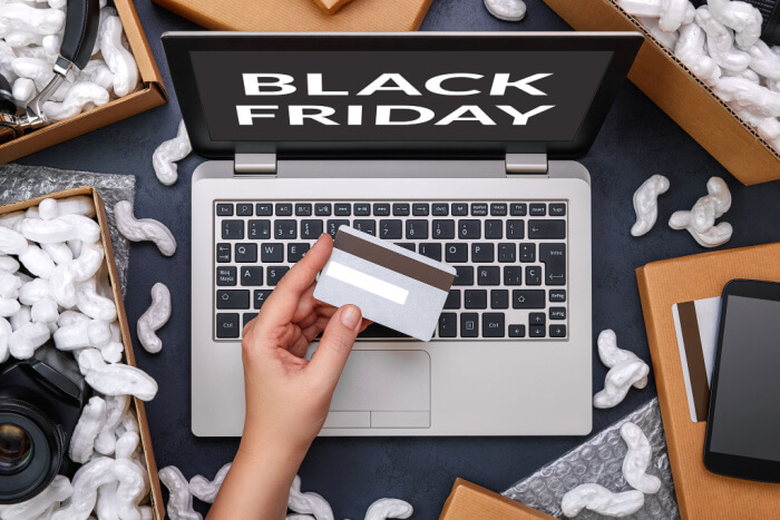 Pessoa utilizando o cartão de crédito para fazer suas compras online para aproveitar a Black Friday