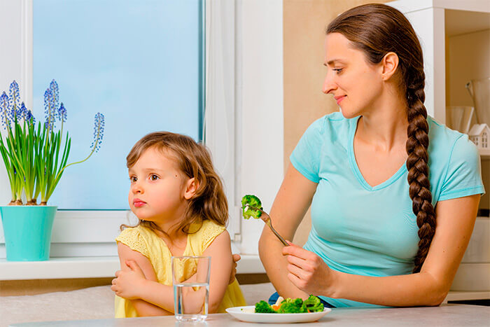 Alimentação saudável para crianças: menina recusando brócolis.