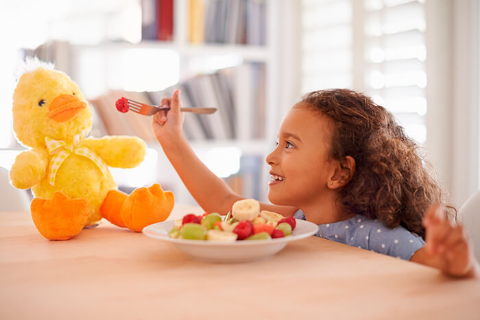 Alimentação saudável para crianças. Garota comendo frutas