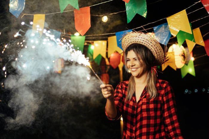 mulher soltando fogos de artifício em festa junina