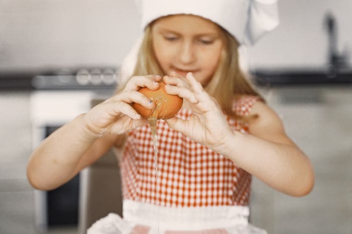 criança de 8 a 10 anos ajudando na cozinha